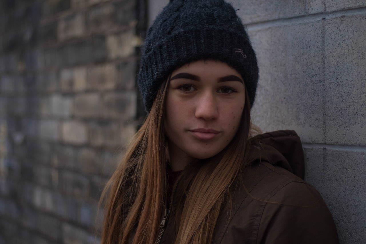 girl in beanie looks in to camera
